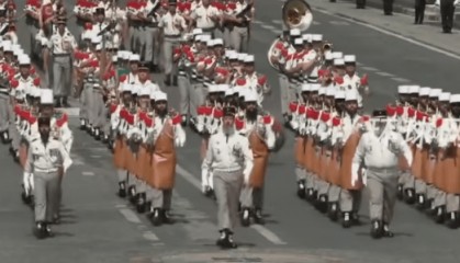 法国阅兵现场,马克龙与第一夫人边看边讨论,其中一方阵人均大胡子,扛着斧头走过